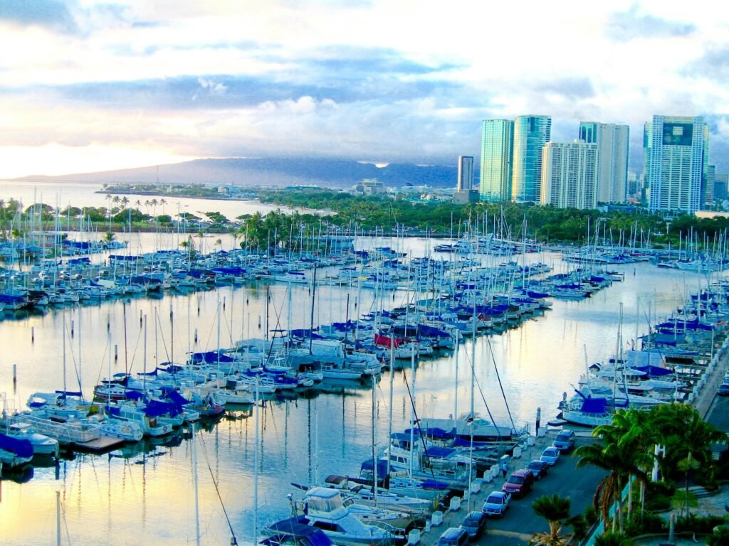 Picturesque harbor with yachts and city skyline in Honolulu, Hawaii during daytime.